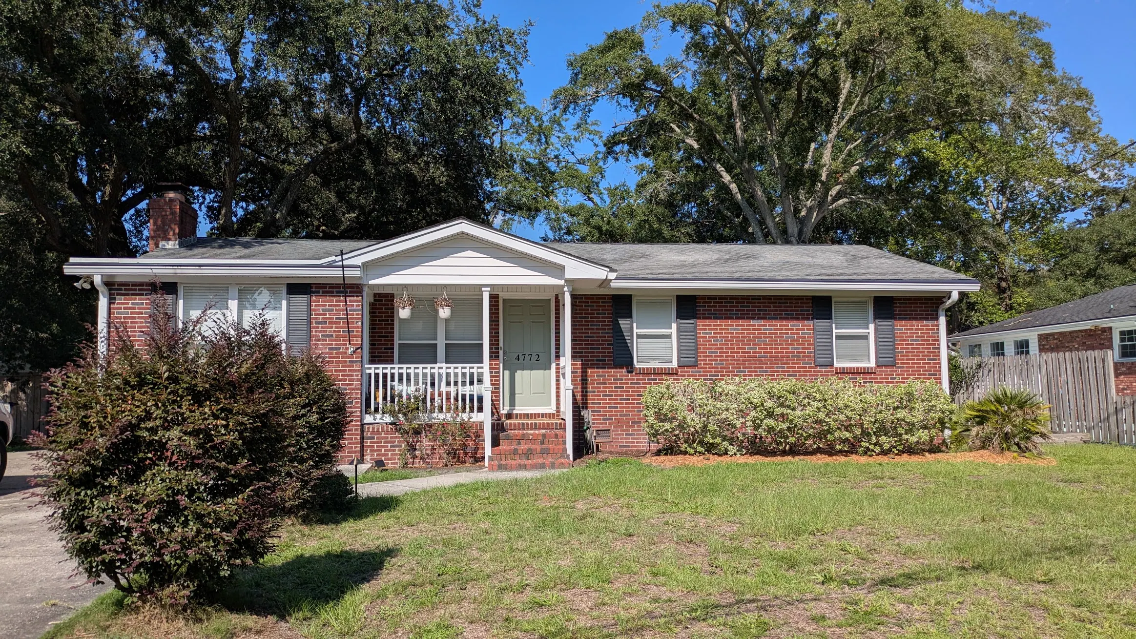 Charleston area home before landscape lighting with a dark front yard, walkway, and trees