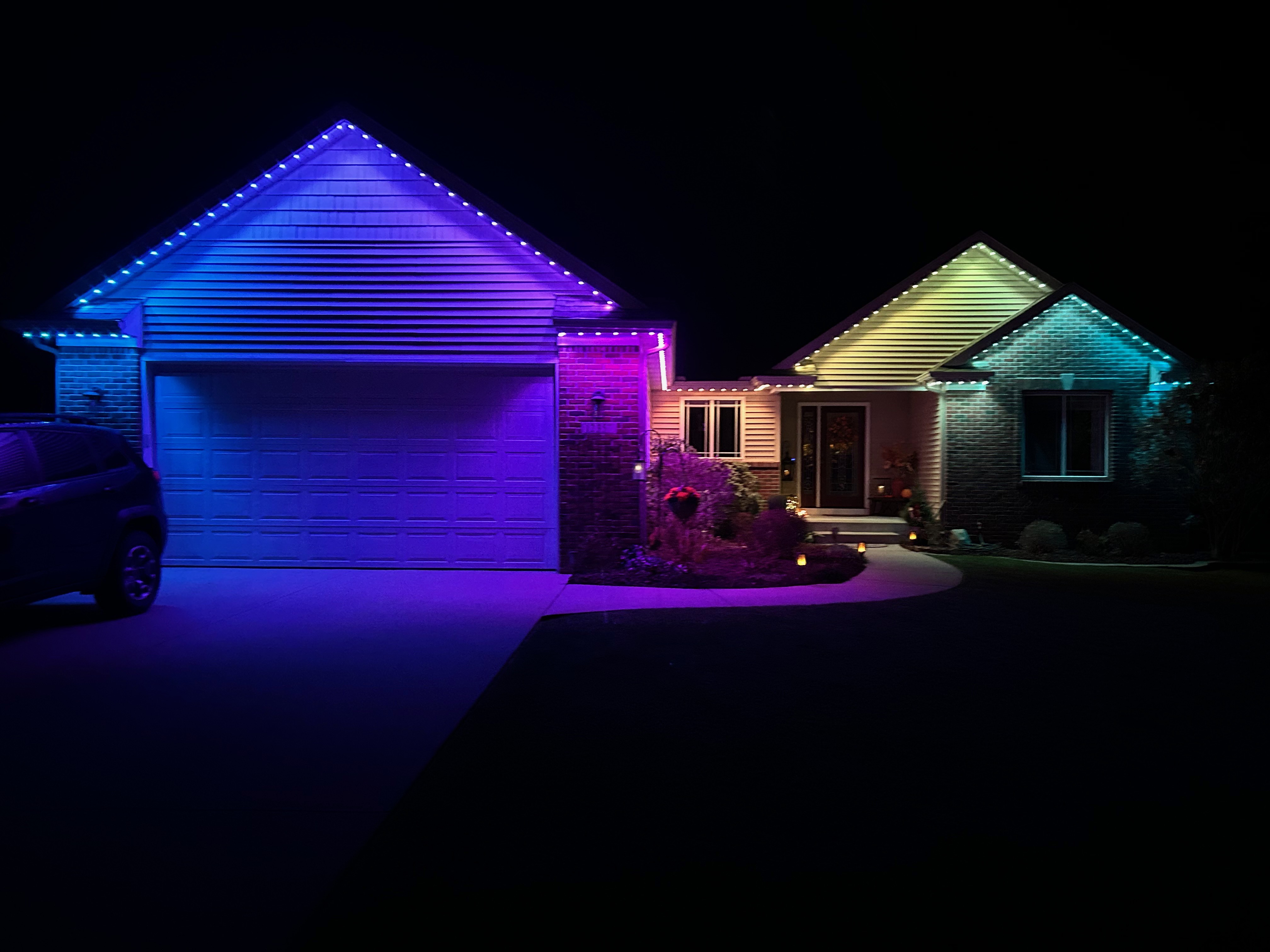Color changing permanent outdoor lighting installed along a Charleston home roofline at night