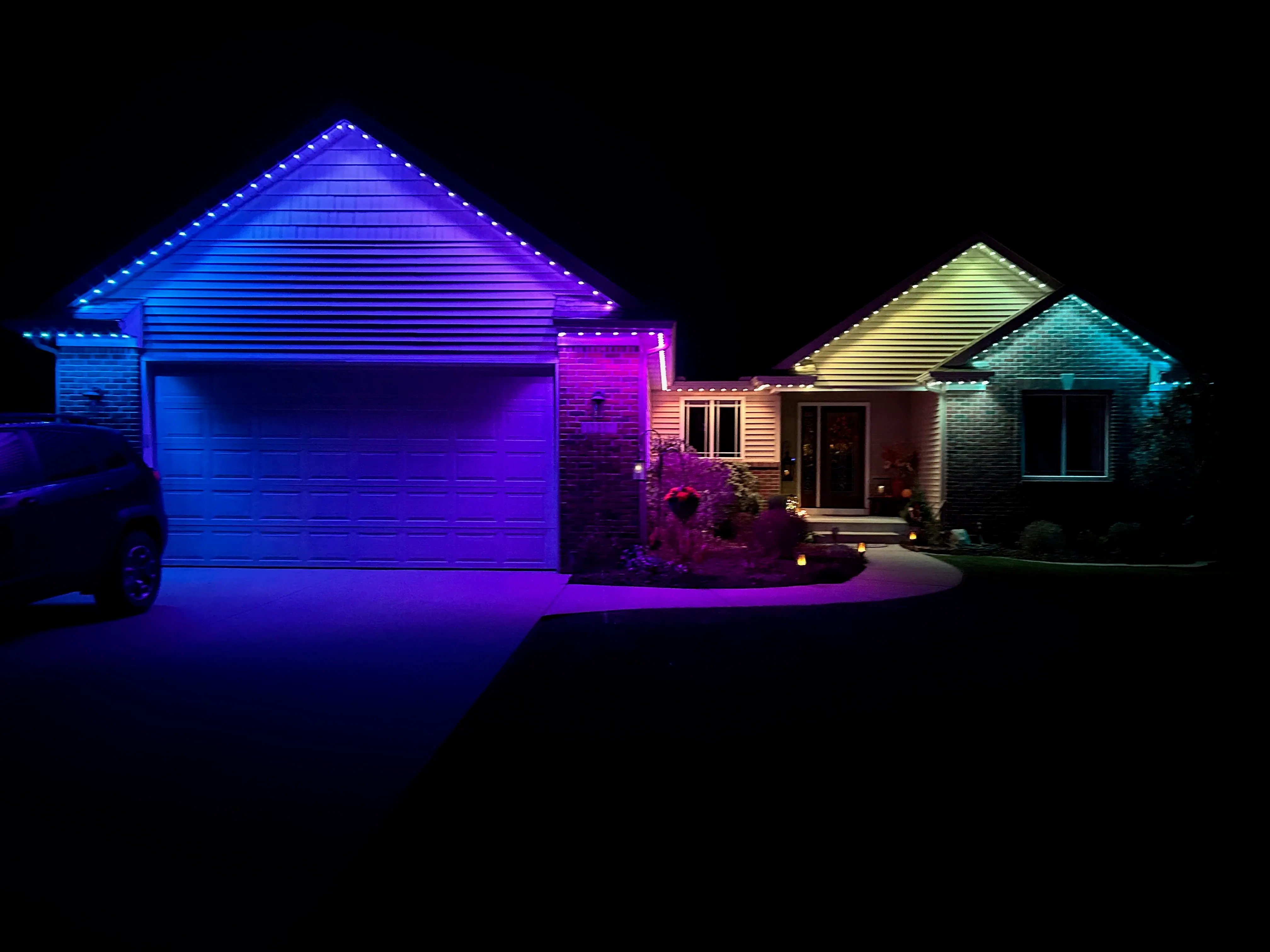 Color changing permanent outdoor lighting installed along a Charleston home roofline at night
