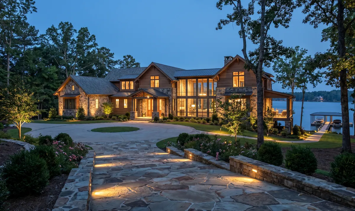 Warm low voltage landscape lighting illuminating a Charleston style home with palm tree uplighting and path lights at dusk